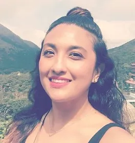 A woman is taking a selfie in front of mountains.